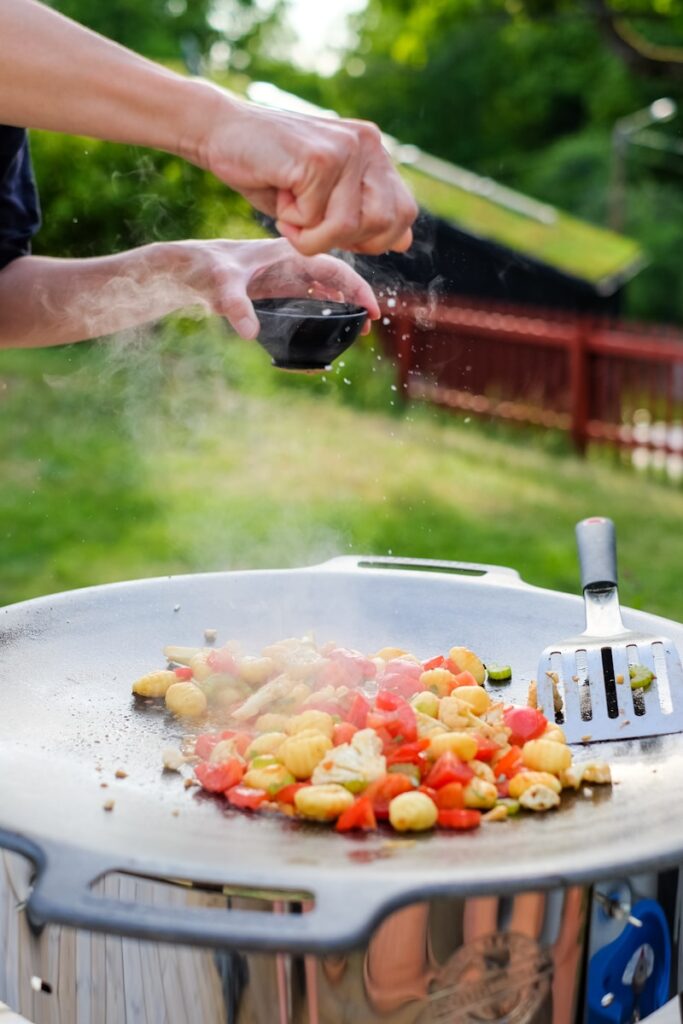 person holding stainless steel fork and knife slicing vegetable